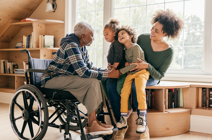 Grandmother in wheelchair talking to family